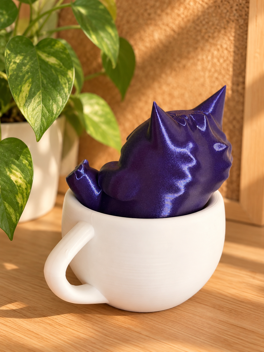 Vista trasera de la figura de Gengar en color morado brillante dentro de una taza blanca